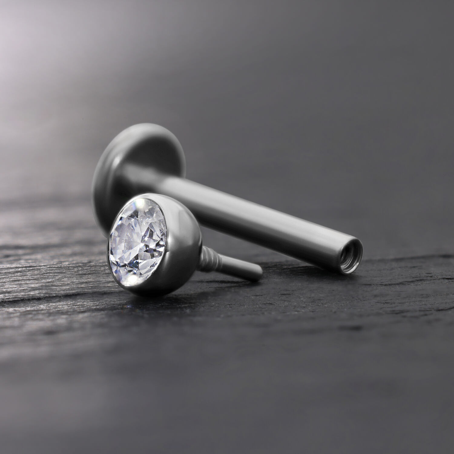 Accessorio Labret argento con sfera di cristallo chiara su sfondo grigio