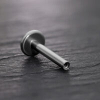 Barra Labret in titanio nero con filettatura interna su sfondo nero