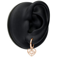 Mini orecchini a cuore in oro rosa su modello di orecchio nero