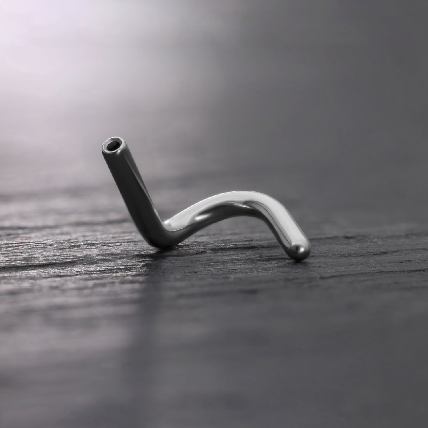 Piercing al naso Push Fit in titanio argento su sfondo scuro