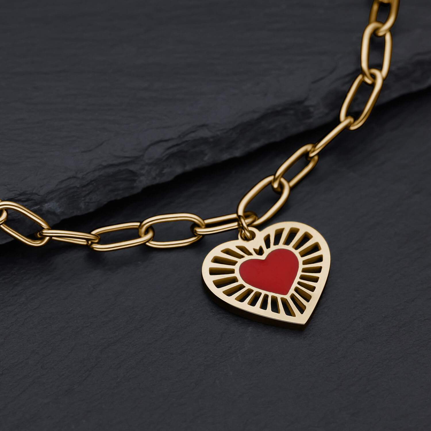 Bracciale dorato con ciondolo a cuore su sfondo nero