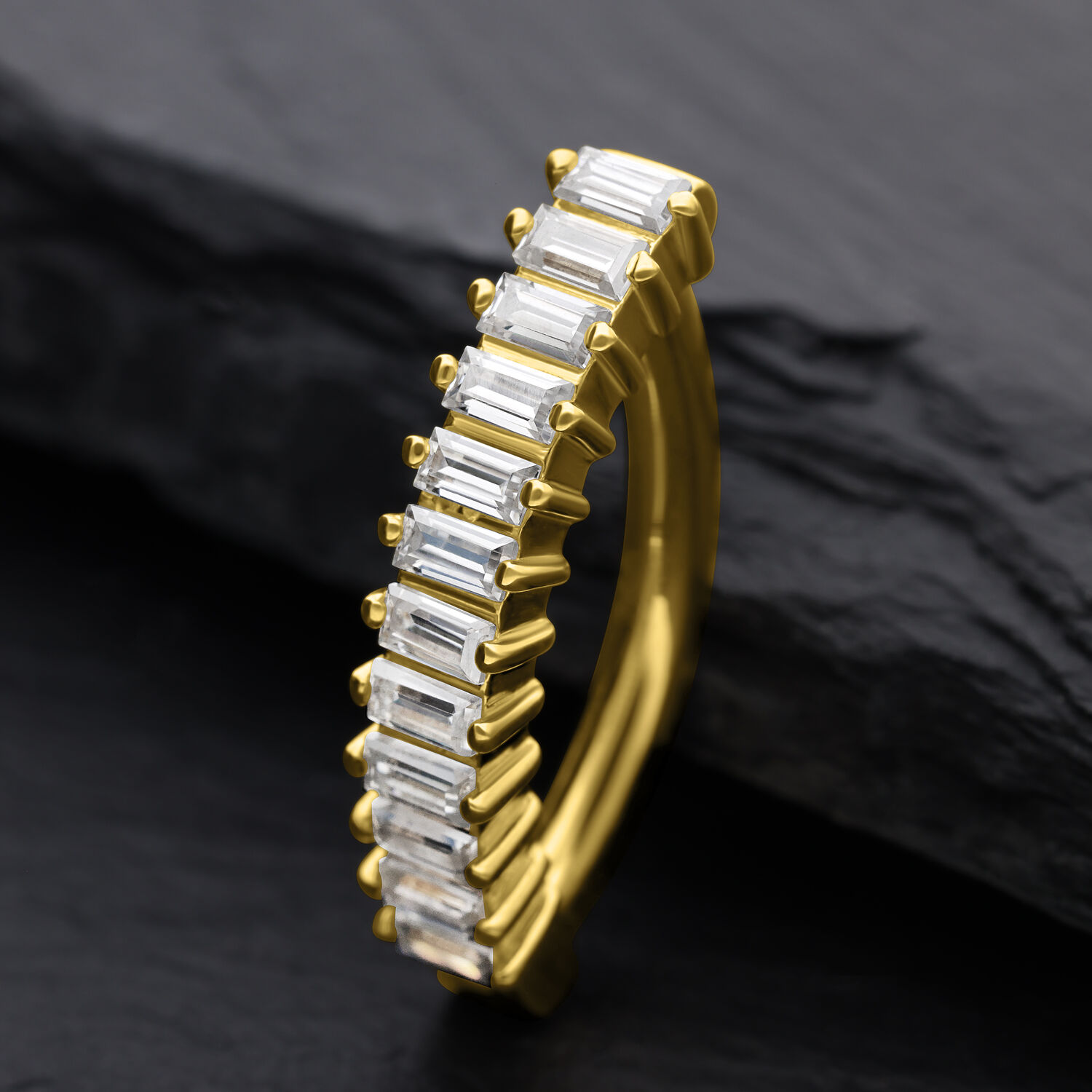 Clicker ombelico d'oro con cristalli Moissanite Baguette su sfondo scuro