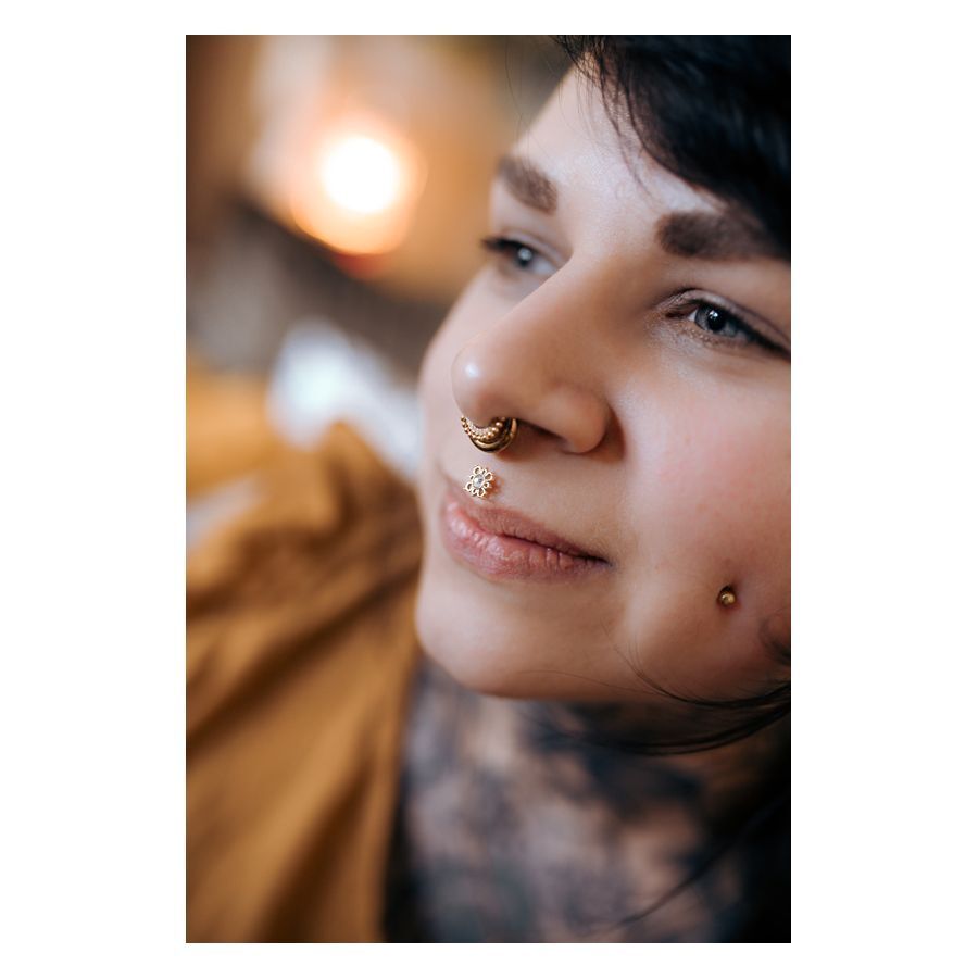 Primo piano di una persona con Oriental Sun Push-Fit Labret nel piercing al naso, colore oro