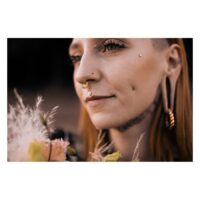 Donna con Flower Push-Fit Labret nell'orecchio, circondata da fiori, all'aperto