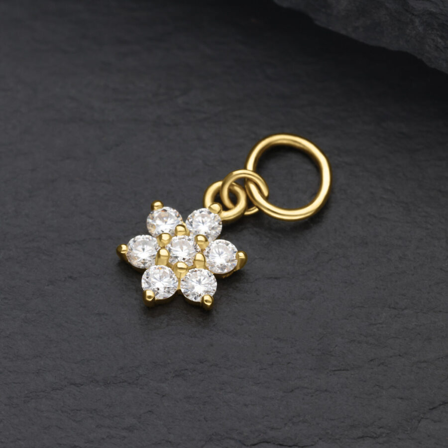 Pendente a fiore dorato in oro 18K con cristalli di moissanite chiari su sfondo nero