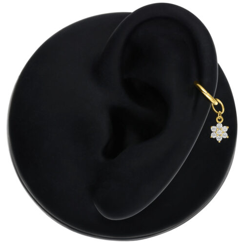 Ciondolo a fiore dorato con Moissanite su un orecchio su sfondo nero