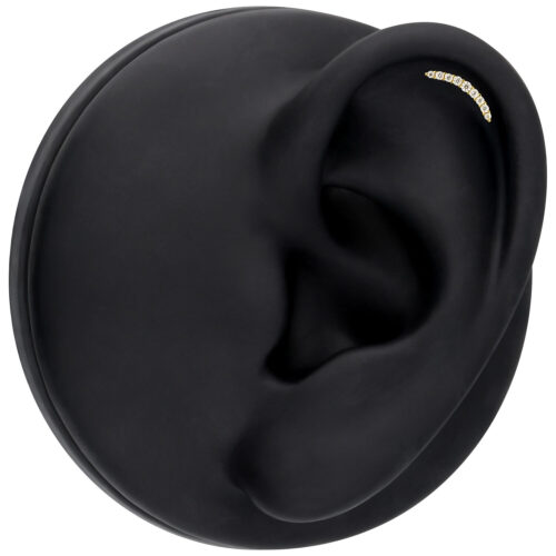 Inserto dorato con cristalli di moissanite in un display nero per orecchio