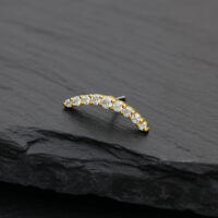 Accessorio ad arco dorato con cristalli di moissanite chiari su sfondo nero