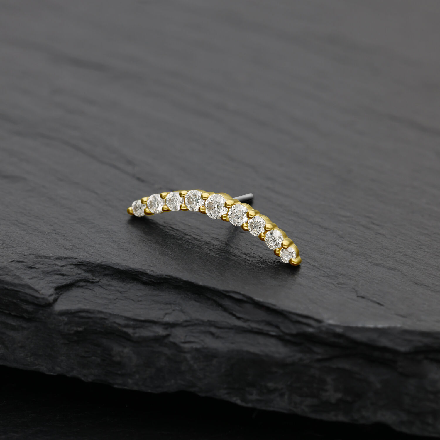 Accessorio ad arco dorato con cristalli di moissanite chiari su sfondo nero