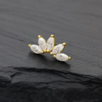 Attacco dorato con pietre di moissanite chiare su sfondo scuro