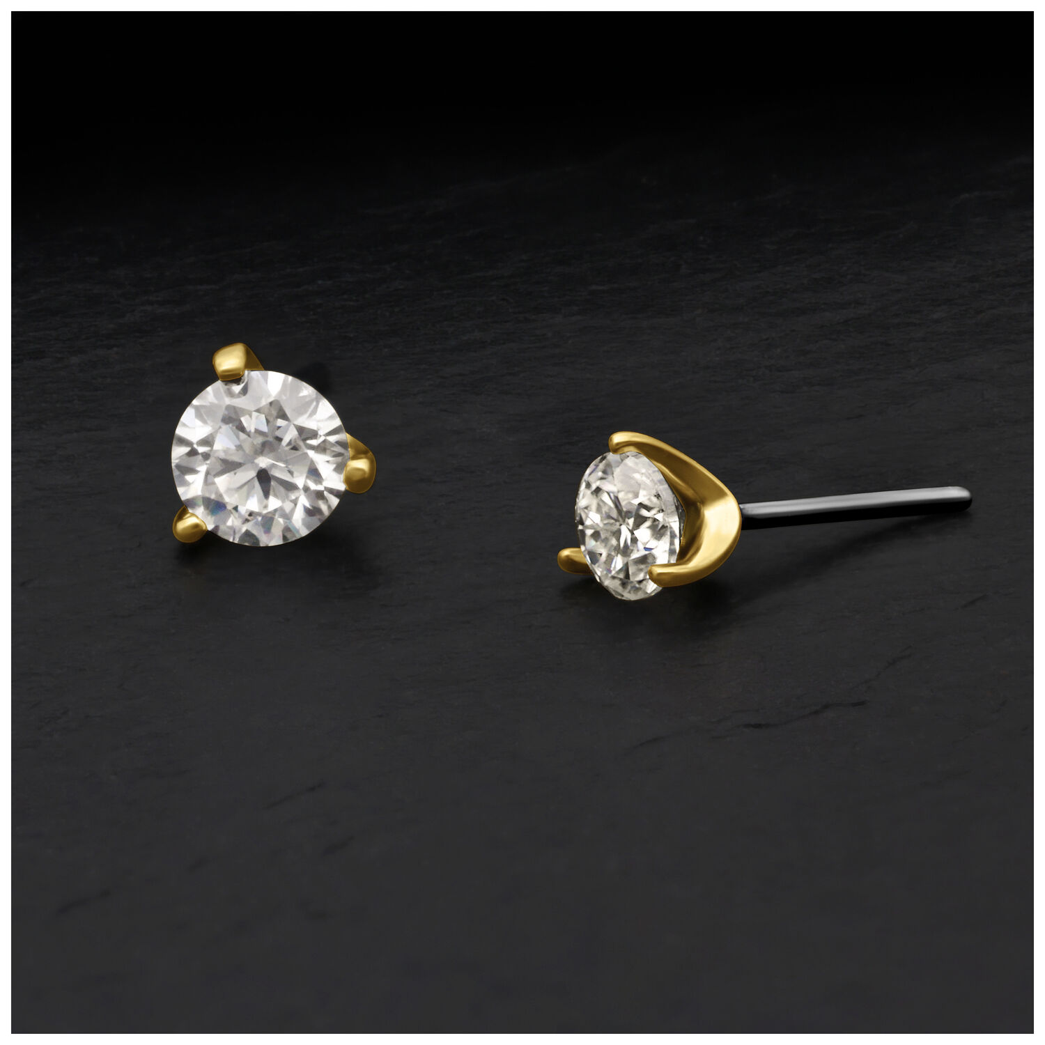 Due attacchi in oro con moissanite in Push-Fit su sfondo nero