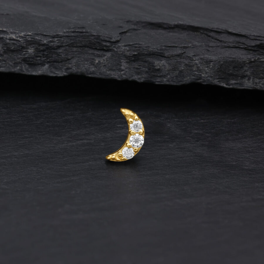 Luna dorata con pietre di moissanite cristalline su sfondo scuro