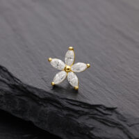 Attacco floreale dorato con pietre di moissanite su sfondo nero