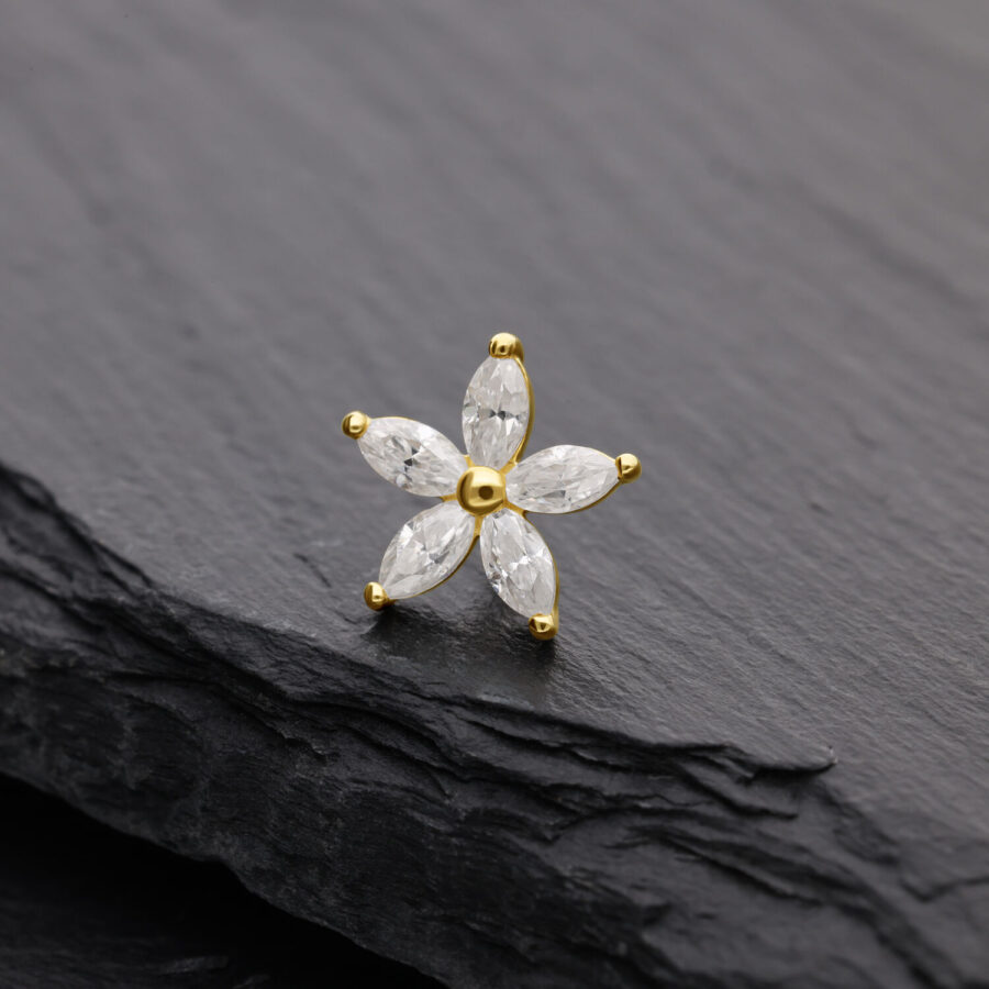 Attacco floreale dorato con pietre di moissanite su sfondo nero