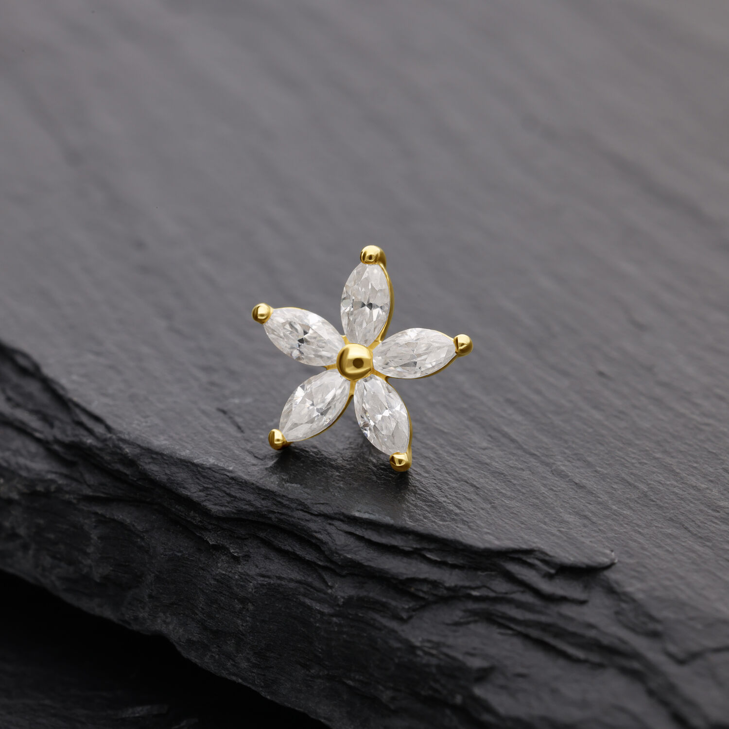 Attacco floreale dorato con pietre di moissanite su sfondo nero
