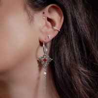 Donna con orecchini, cerchi argento con ciondolo a cuore rosso e catene, piercing all'orecchio