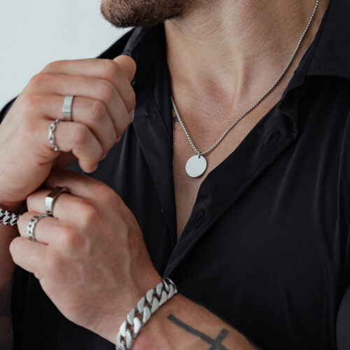 Collana unisex in acciaio chirurgico, indossata da una persona con camicia nera