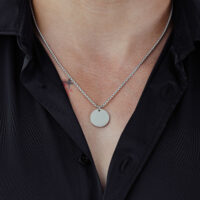 Collana d'argento con pendente rotondo su camicia nera