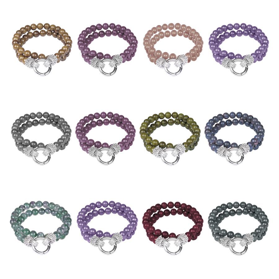 Dodici braccialetti in acciaio chirurgico in beige, blu, marrone, grigio, viola su sfondo bianco