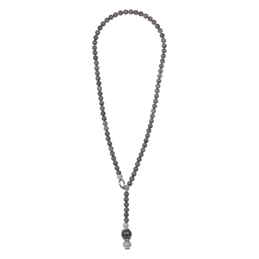 Lunga collana nera con perle rotonde e ciondolo su sfondo bianco