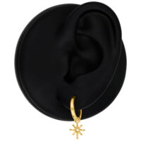 Mini Polar Star Hoops in oro su modello d'orecchio nero davanti a sfondo neutro