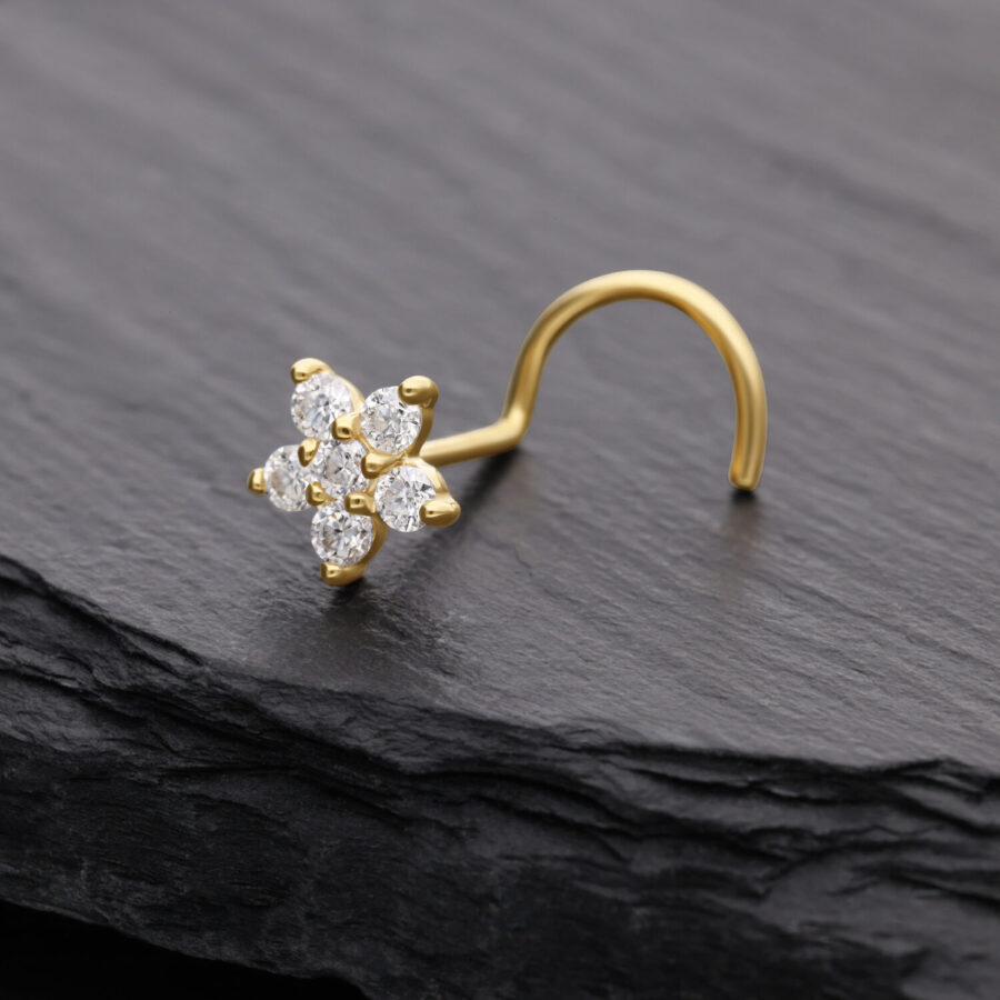 Piercing al naso in oro con cristallo di moissanite a forma di fiore su sfondo scuro