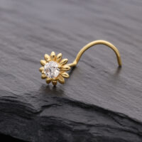 Piercing al naso dorato a forma di girasole con cristallo chiaro su sfondo scuro