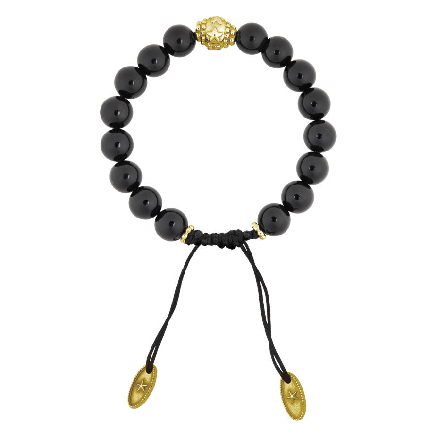 Bracciale in onice nero con perla dorata e due ciondoli dorati su sfondo bianco