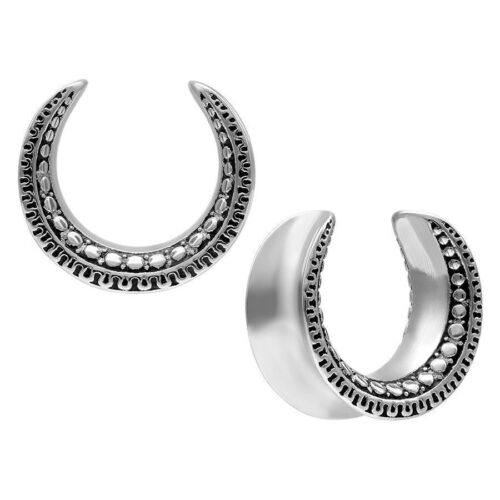 Due Ear Saddles argentati con motivo Maori su sfondo bianco