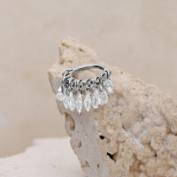 Anello piercing in argento con cristalli chiari su sfondo beige