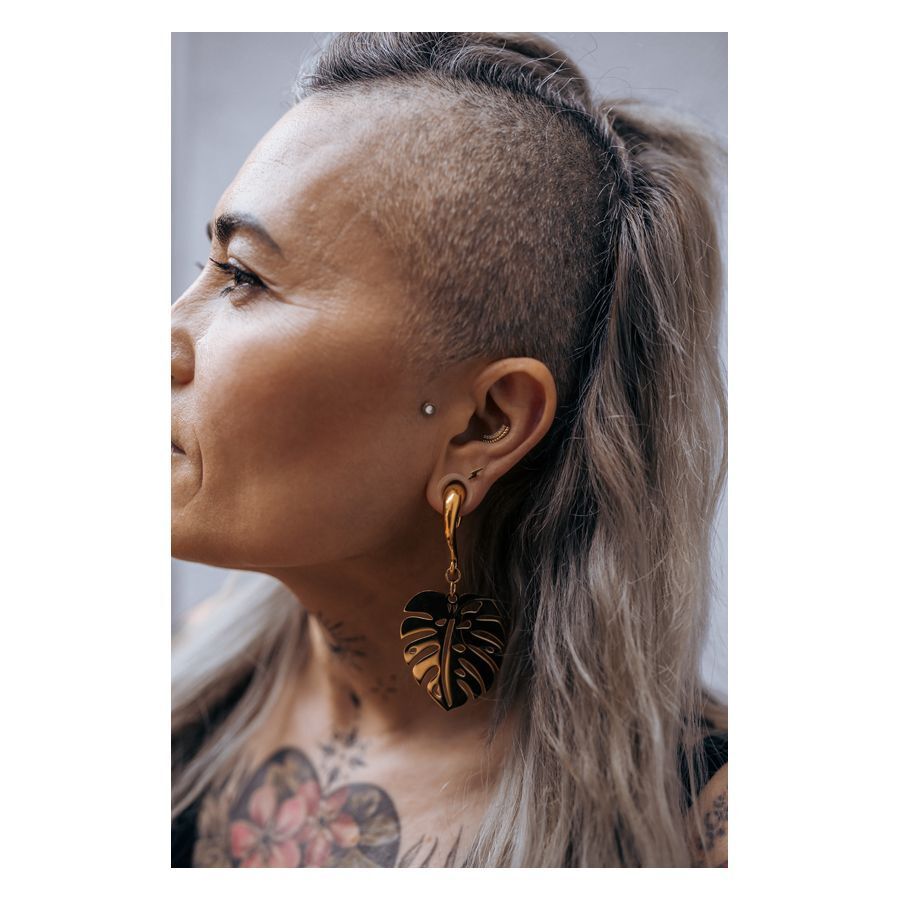 Persona con Flash Earbarbell dorato nell'orecchio, vista laterale