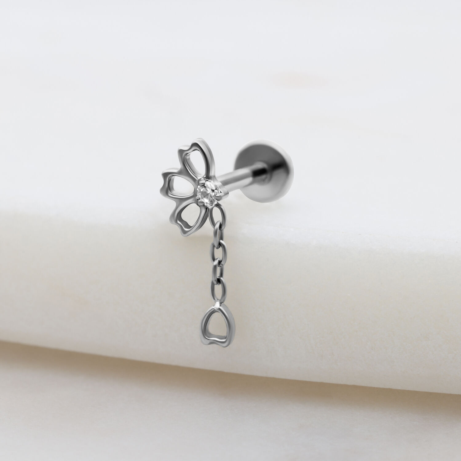 Inserto piercing argento con catena di cristalli chiari su sfondo bianco