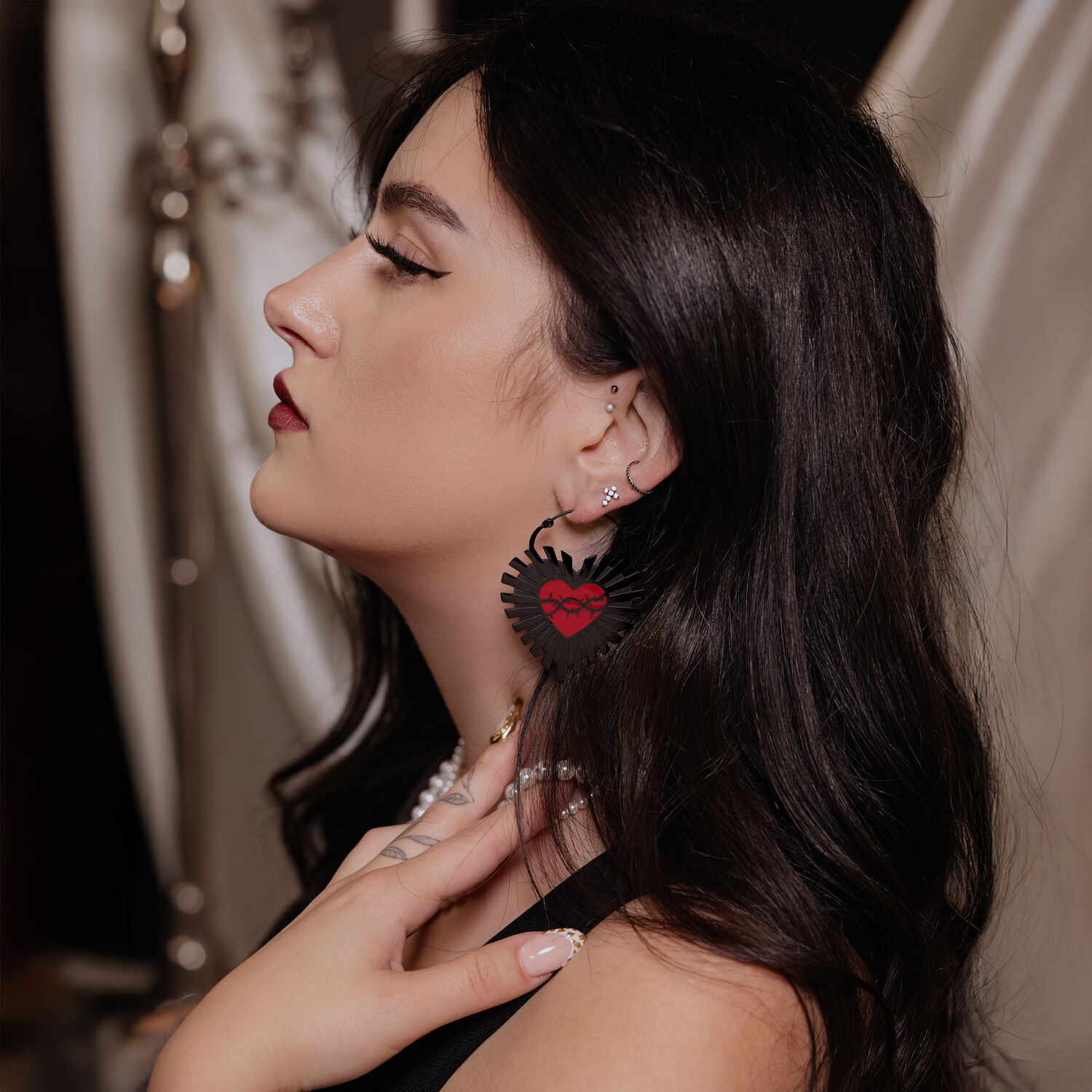 Donna con lunghi capelli scuri indossa orecchini a cerchio Sacred Heart neri in acciaio chirurgico