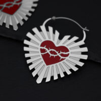 Orecchini in argento a forma di cuore con corona di spine rossa su sfondo nero