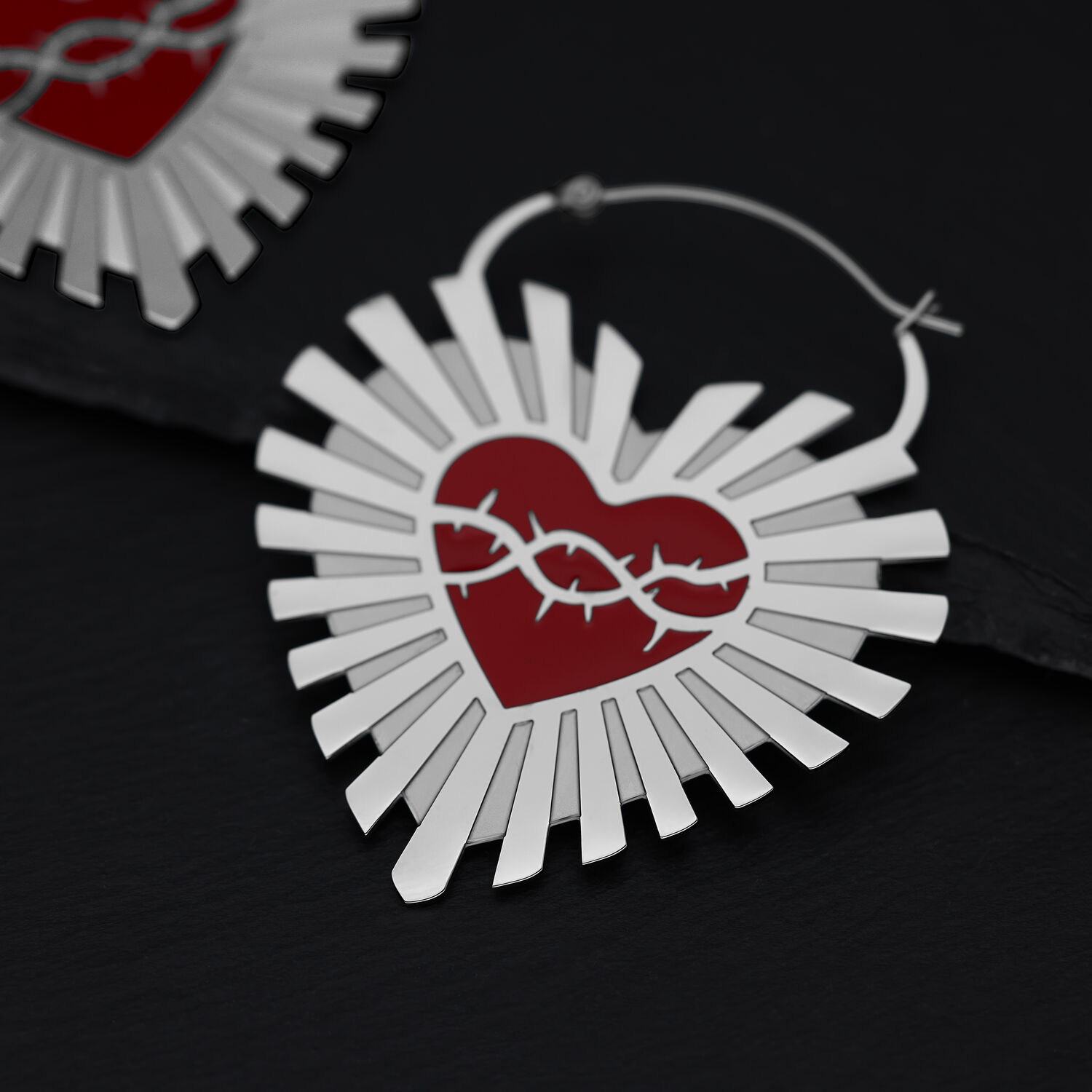 Orecchini in argento a forma di cuore con corona di spine rossa su sfondo nero