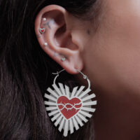 Orecchini in argento a forma di cuore con motivo di filo spinato su un orecchio