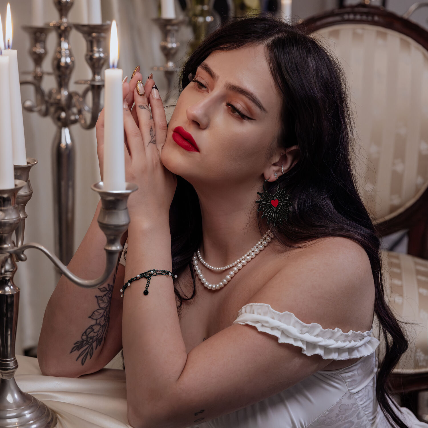 Donna con orecchini Sacred Heart Hoops neri in un ambiente elegante