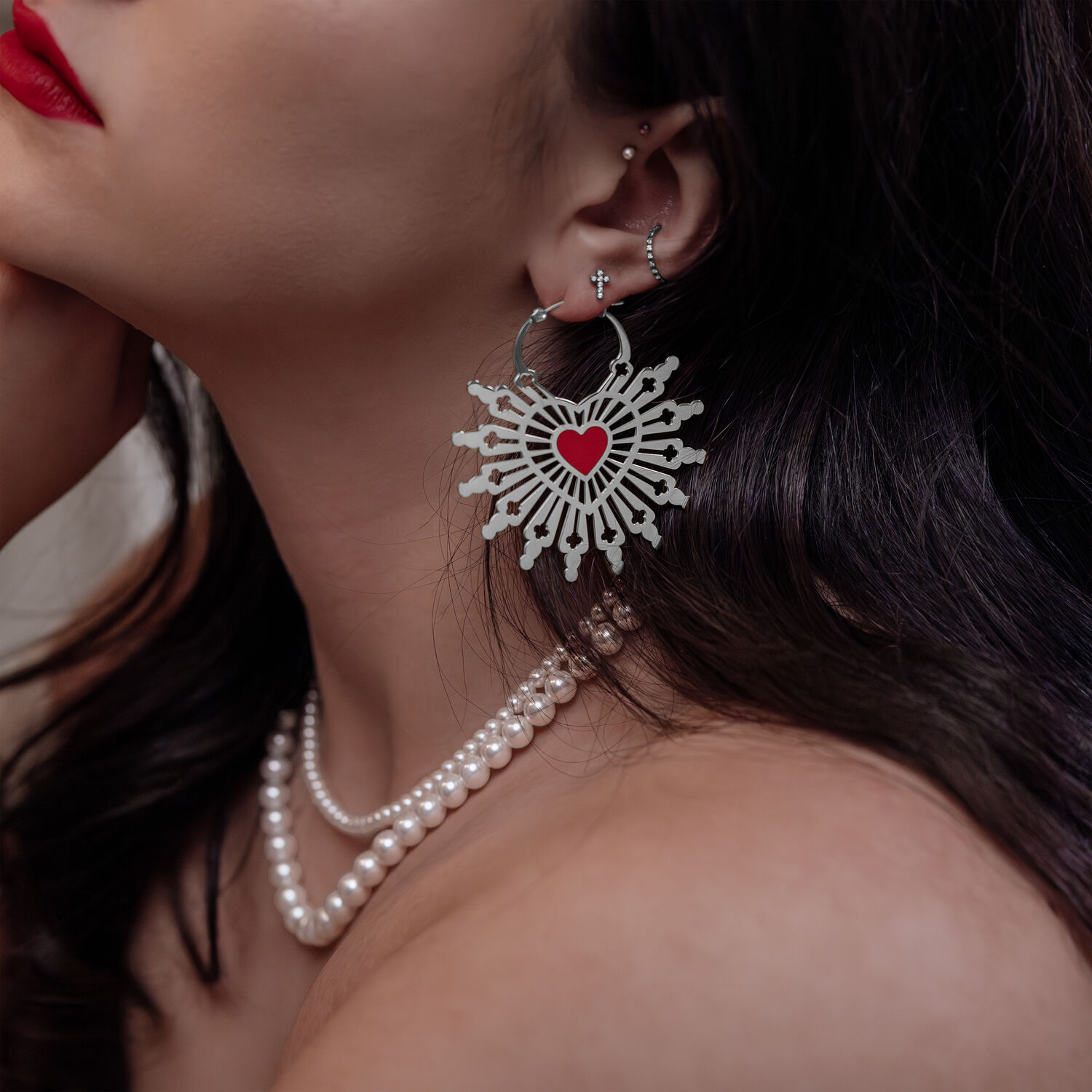 Donna con orecchini Sacred Heart in argento e nero, primo piano