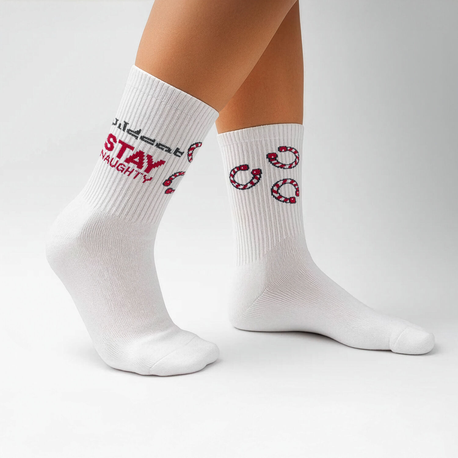 Calze bianche con motivi di candycane rossi e testo nero su sfondo grigio
