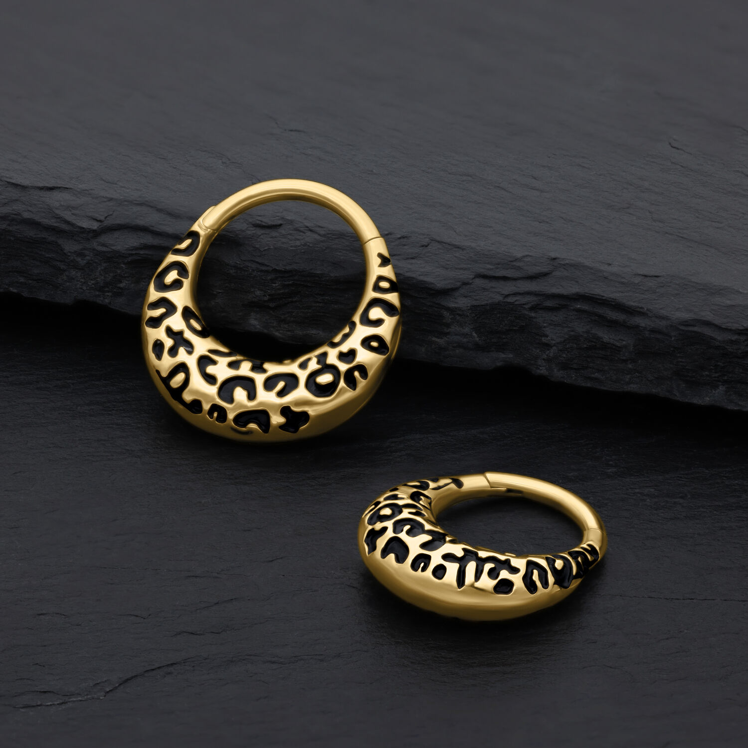 Due clicker per setto dorati con motivo leopardo su sfondo nero