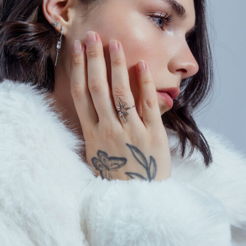 Donna con anello Polar Star in acciaio chirurgico, primo piano, sfondo bianco