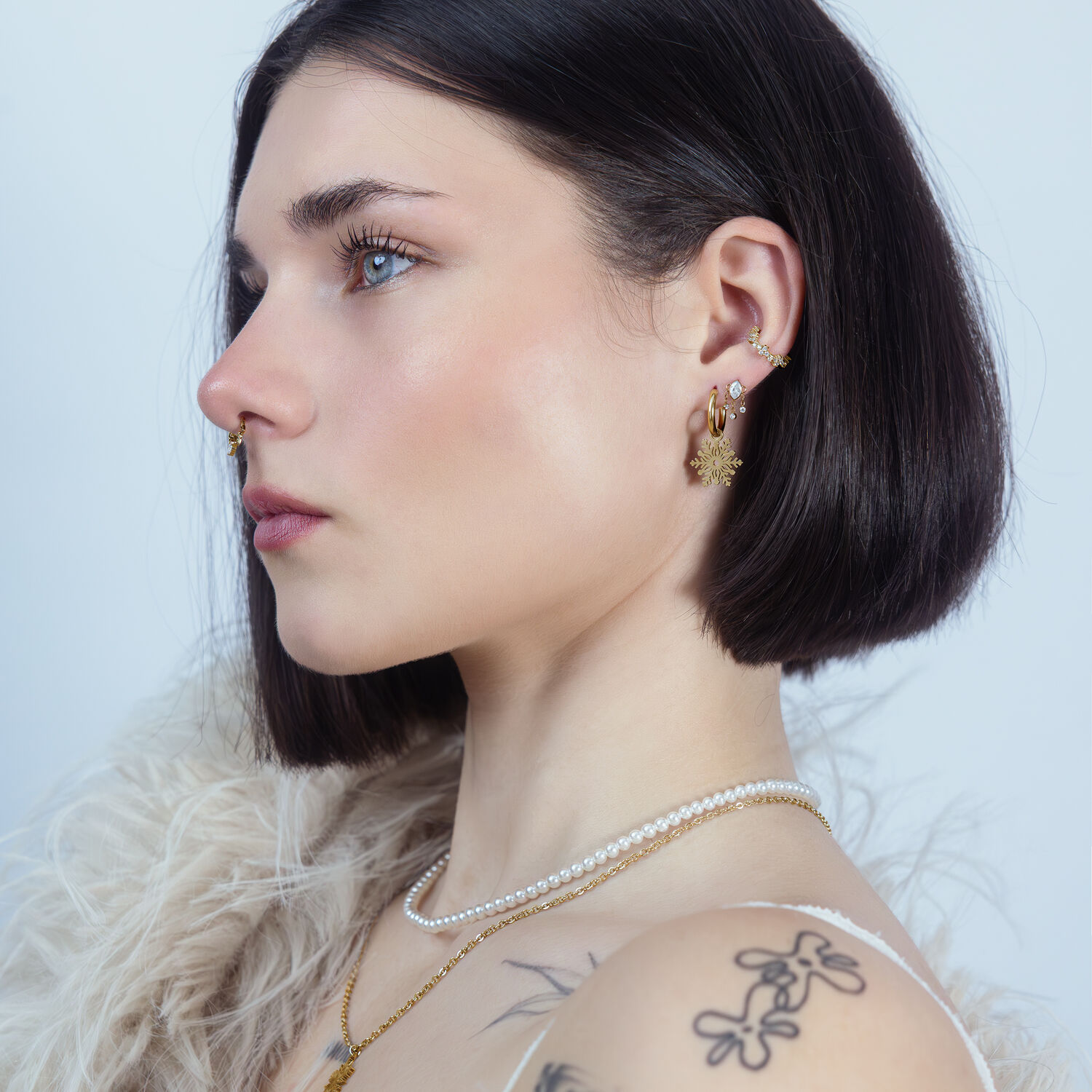 Donna con capelli corti e scuri indossa un cristallo Push Fit dorato all'orecchio