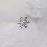 Punta piercing a fiocco di neve argentata con cristallo trasparente su sfondo bianco