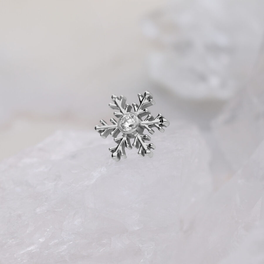 Punta piercing a fiocco di neve argentata con cristallo trasparente su sfondo bianco