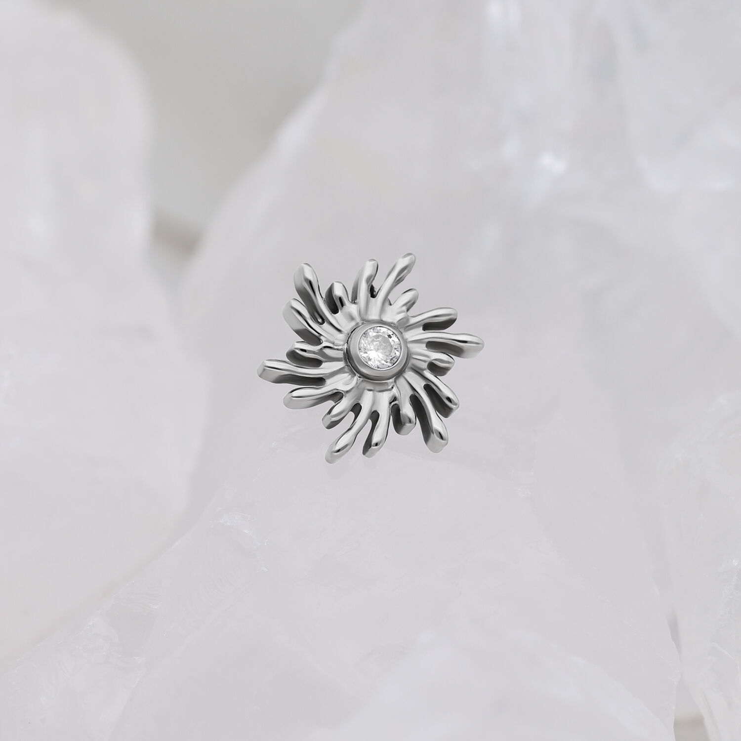 Argento Sunburst con pietra cristallina su sfondo bianco