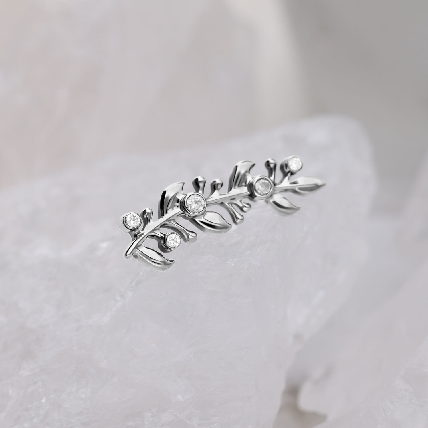 Attacco in titanio argento con pietre cristalline su sfondo bianco