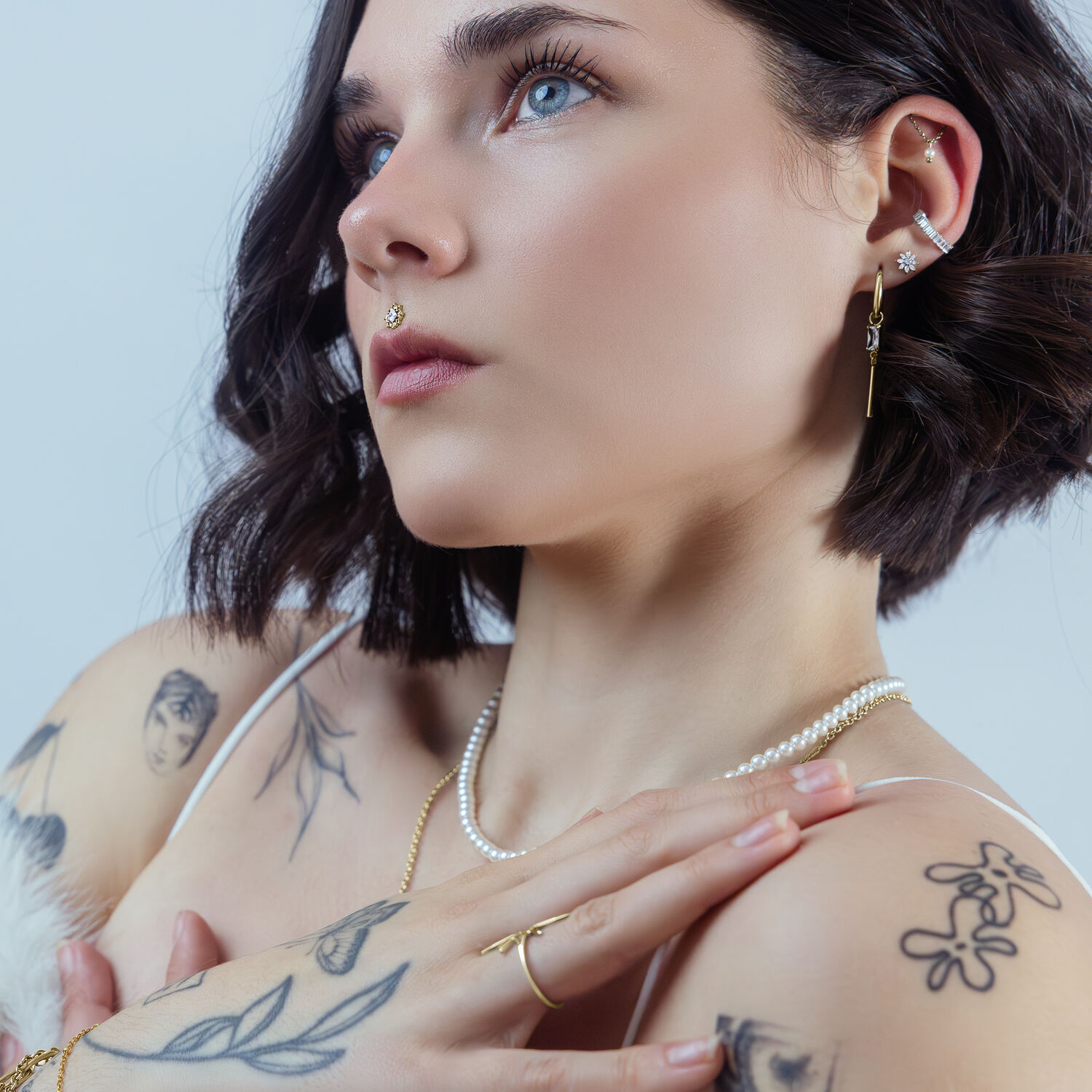 Donna con cristallo dorato Push Fit in piercing all'orecchio su sfondo chiaro