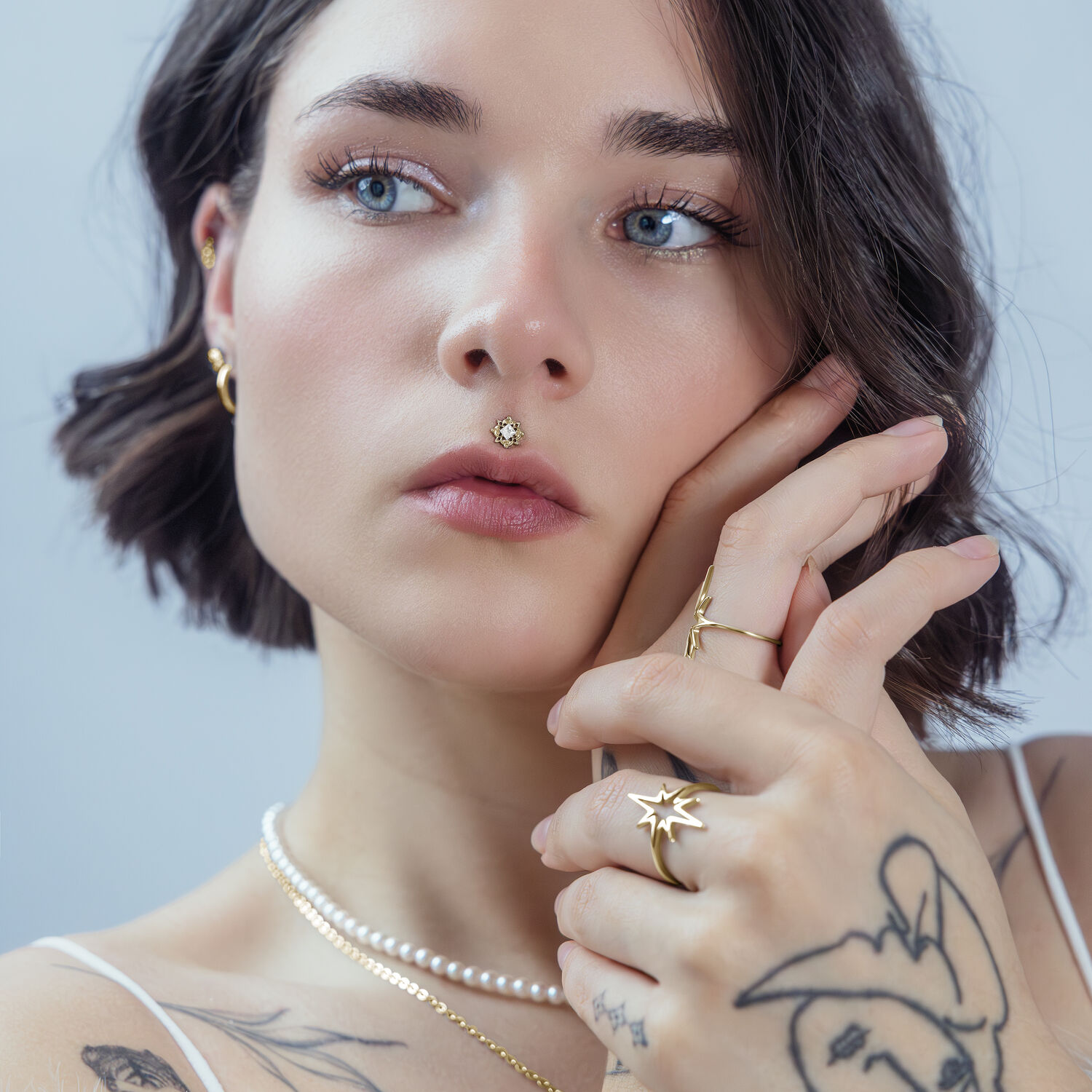 Donna con ornamento dorato nel piercing al naso, luce soffusa