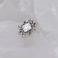 Accessorio in titanio argento con pietra cristallina su sfondo bianco