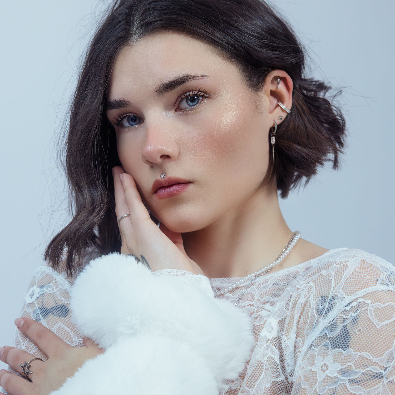 Donna con capelli corti indossa un inserto a stella push fit argento all'orecchio, su sfondo bianco